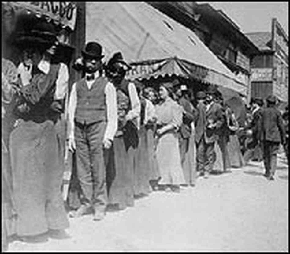 Earthquake survivors wait in a bread line.
