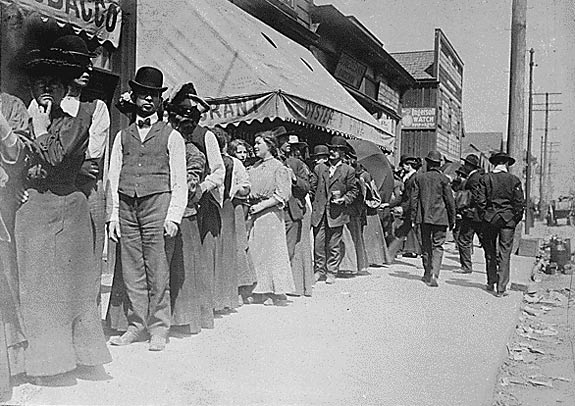 Earthquake survivors wait in a bread line.