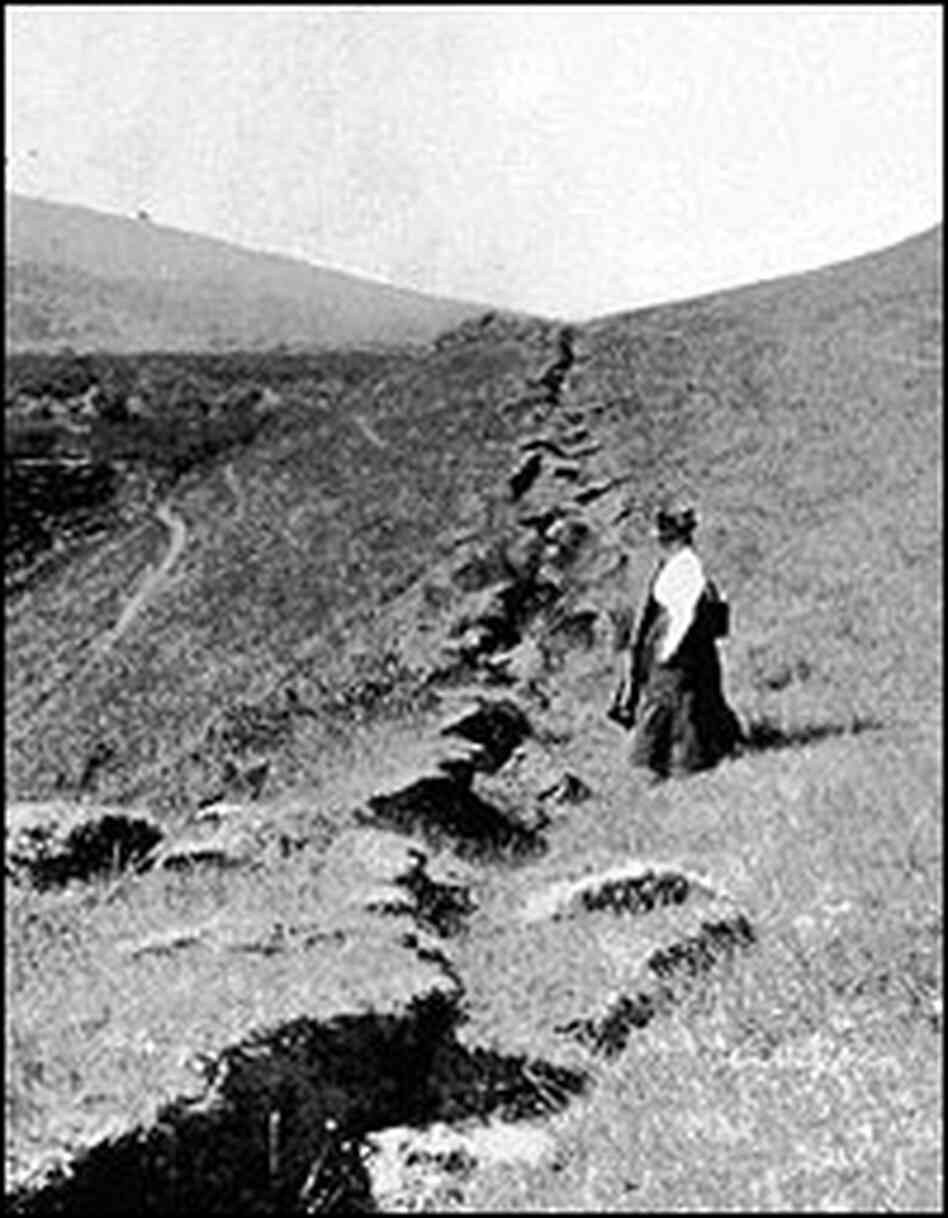 A woman stands near the 1906 ground rupture.