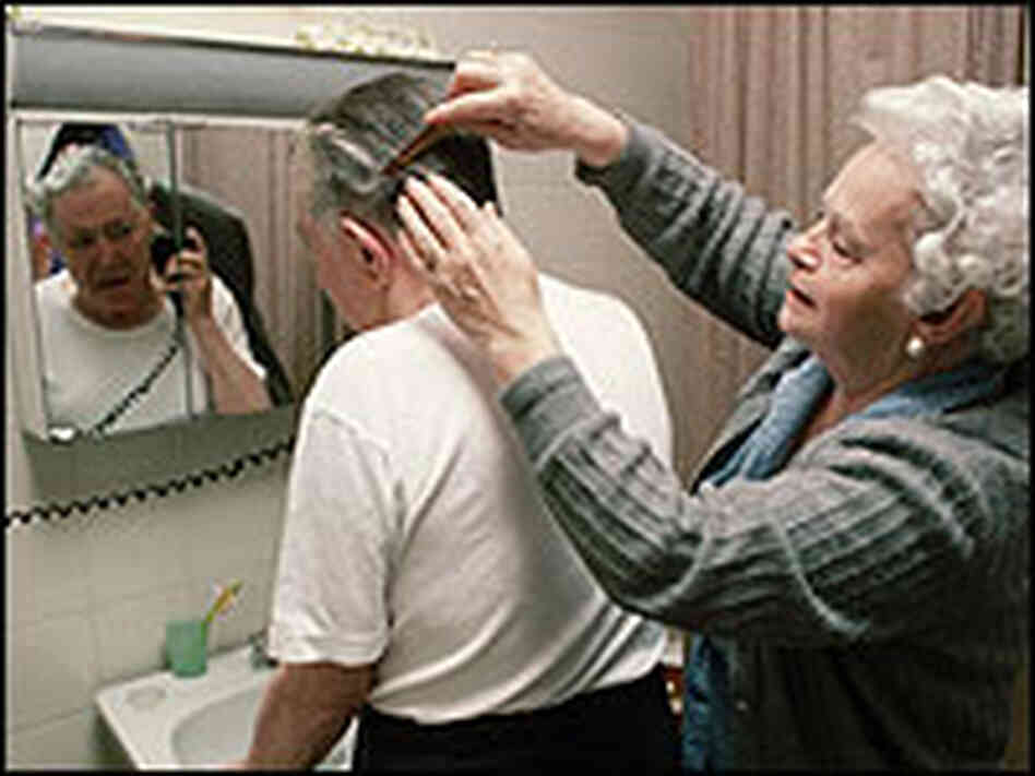 A woman helps her husband, who has Alzheimer's. A woman helps her husband, who has Alzheimer's.