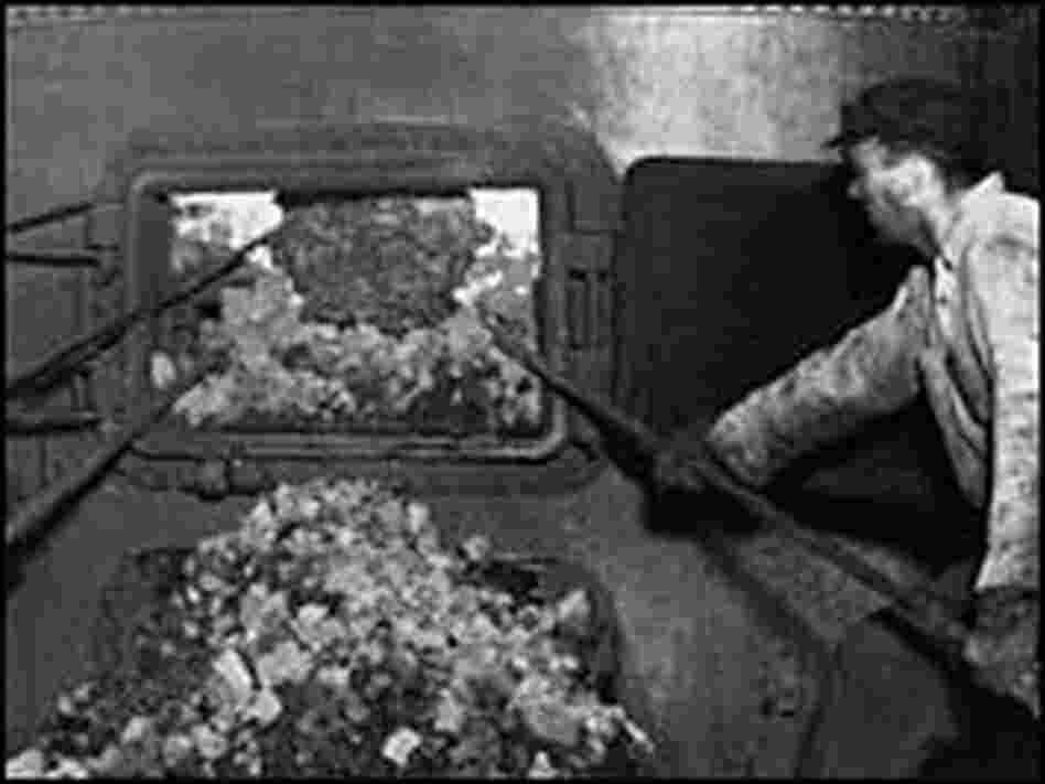 A man stokes a coal oven A man stokes a coal oven