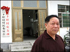 Wu Houhui stands in front of the local Communist Party building. Wu Houhui stands in front of the local Communist Party building.