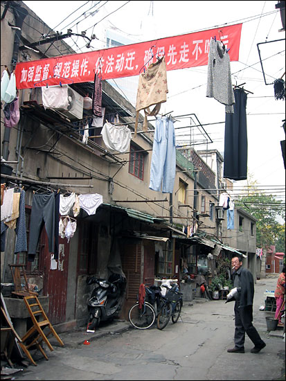Red banners, encouraging residents to move out as soon as possible, festoon the neighborhood.