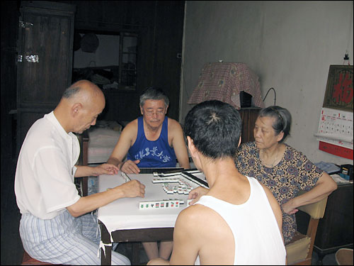 Neighbors play mahjong in Shu Haolun's grandmother's room. 