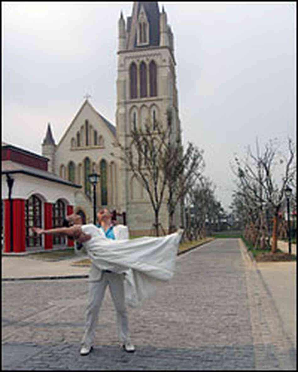 Yang Jinghui and Zi Haiying pose for wedding photographs in front of Thames Town's church.