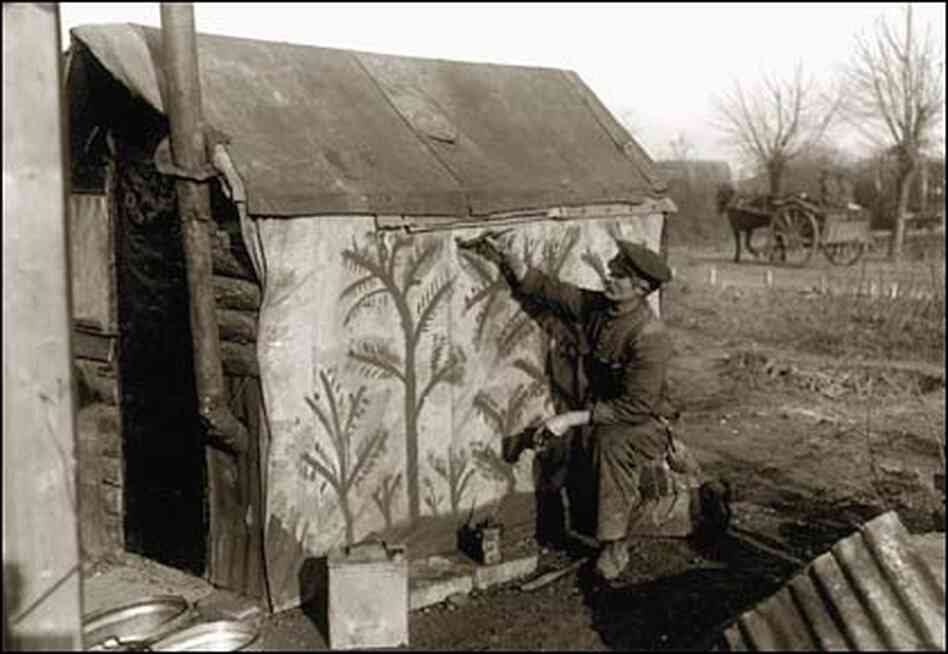 A soldier took the time to paint trees on canvas-like material covering the side of his hut. A soldier took the time to paint trees on canvas-like material covering the side of his hut.