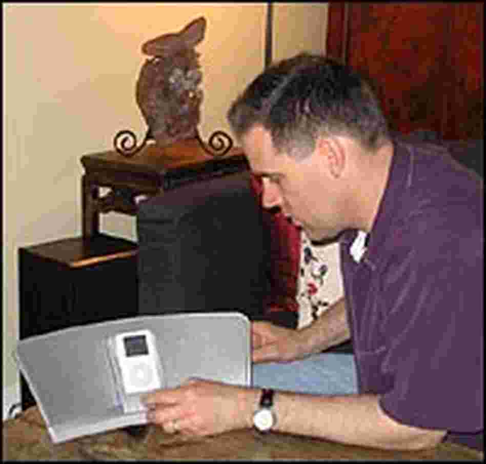 Greg Thomas listens to a docked iPod.