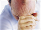 A man holds his head. A man holds his head.