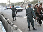 Two Kabul policemen patrol near the site of a suicide bombing that targeted fellow officers. Two Kabul policemen patrol near the site of a suicide bombing that targeted fellow officers.
