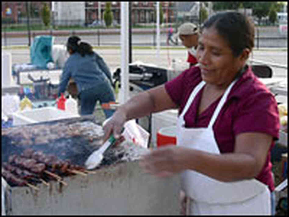 A vendor works a grill at the Camden's Farmers Market, Camden, N.J.