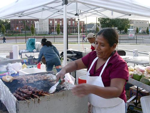A vendor works a grill at the Camden's Farmers Market, Camden, N.J.
