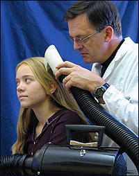 University of Utah biologist Dale Clayton demonstrates the LouseBuster on his daughter.