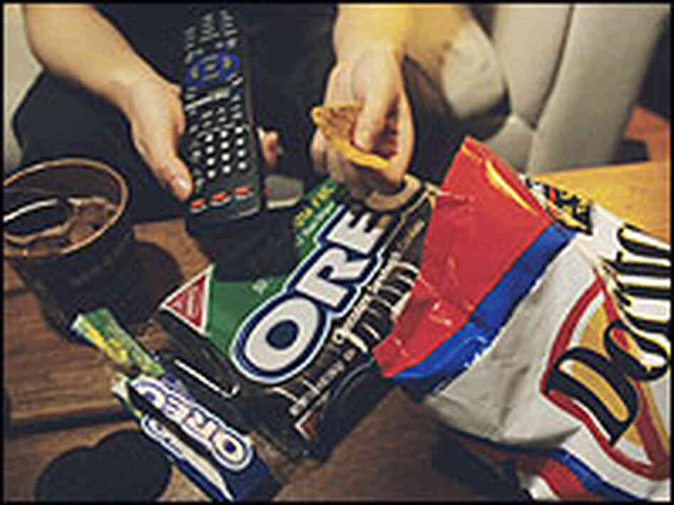 A junk food meal in front of a TV. A junk food meal in front of a TV.