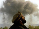 A Northern Alliance commander looks up, as smoke from bombing rises in the background. A Northern Alliance commander looks up, as smoke from bombing rises in the background.