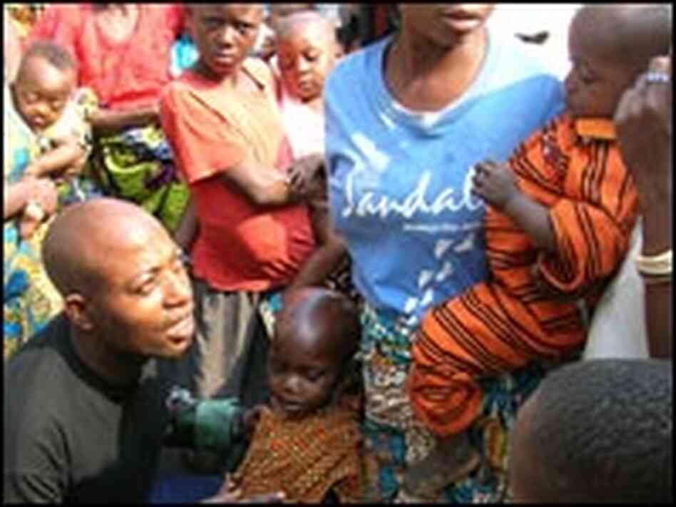 Dr. Isaac Mwinde Mongolari examines a young patient. Dr. Isaac Mwinde Mongolari examines a young patient.