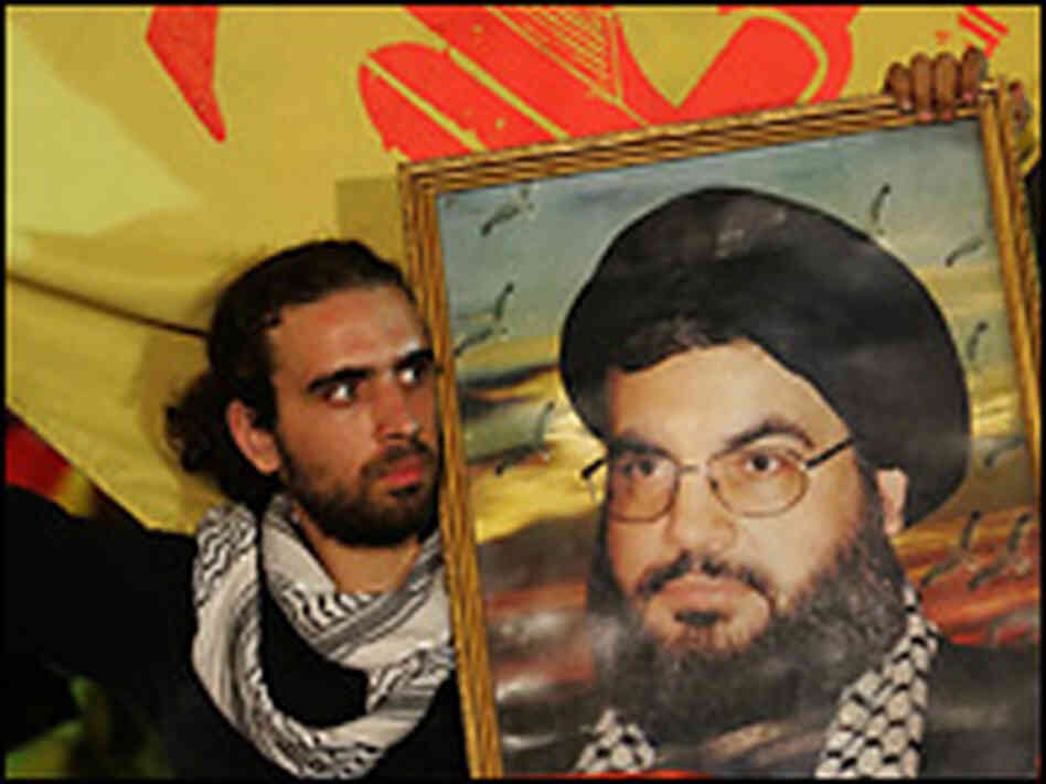 Lebanese Shiite men wave Hezbollah flags. Credit: Hassan Ammar/AFP/Getty Images.