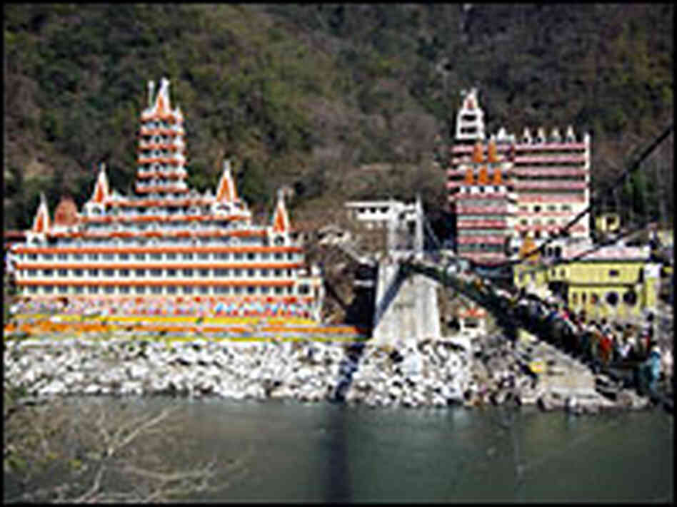 A suspension bridge crosses the Ganges River where she leaves the Himalayas and leads to Rishikesh,