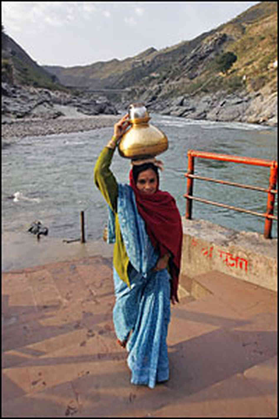 Each morning, women gather holy water from the Ganges in brass pots.