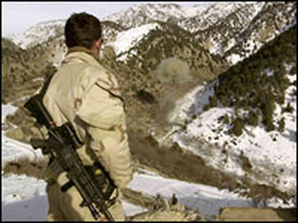 A Navy SEAL patrols an Afghan mountainside.