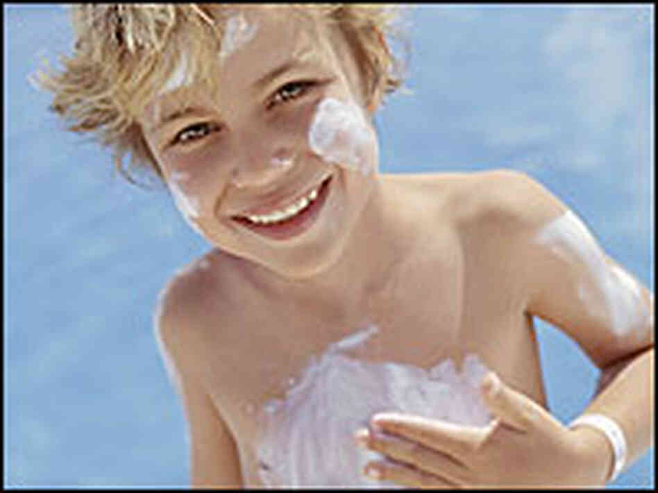 A young boy with sunscreen all over his face and stomach. A young boy with sunscreen all over his face and stomach.
