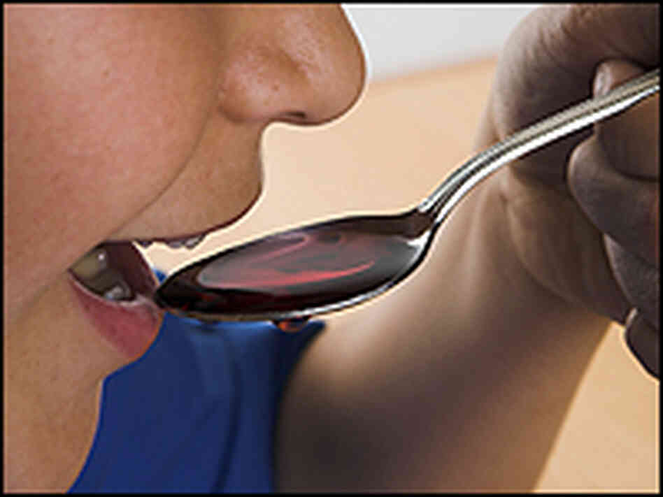 A child holds a spoon of cough syrup A child holds a spoon of cough syrup