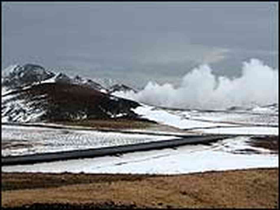Steam from the Krafla power plant billows from behind a mountain.