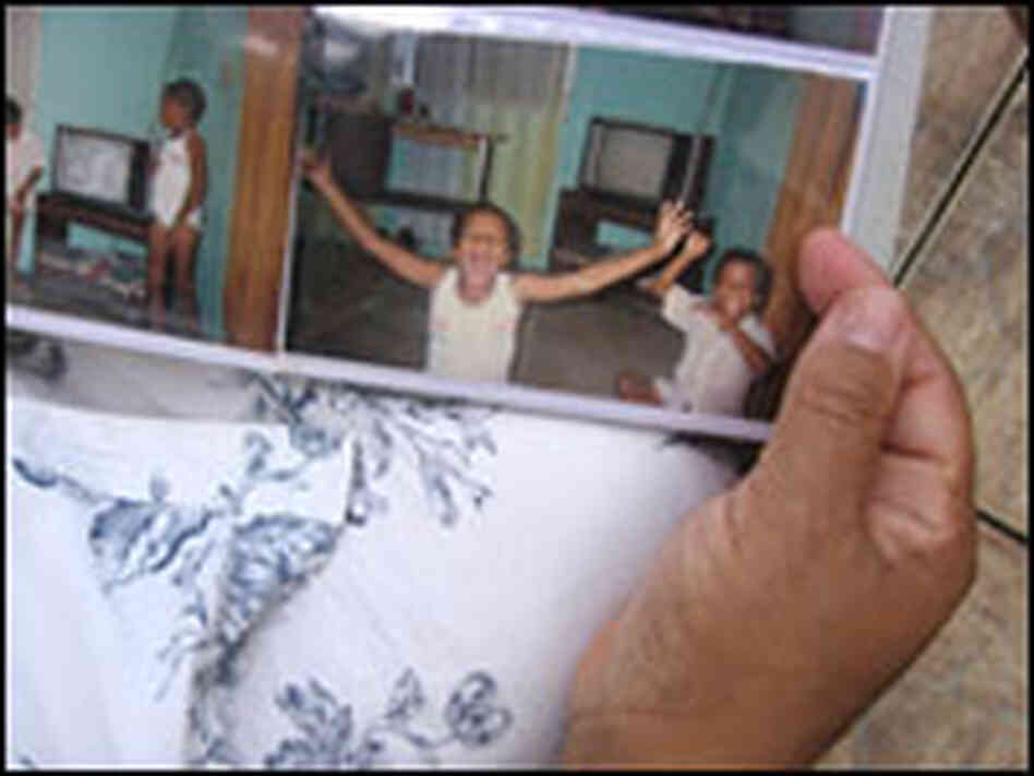 Angela Ramos-Michael holds a photo album with an old snapshot of her brother, Jonathan Ramos.