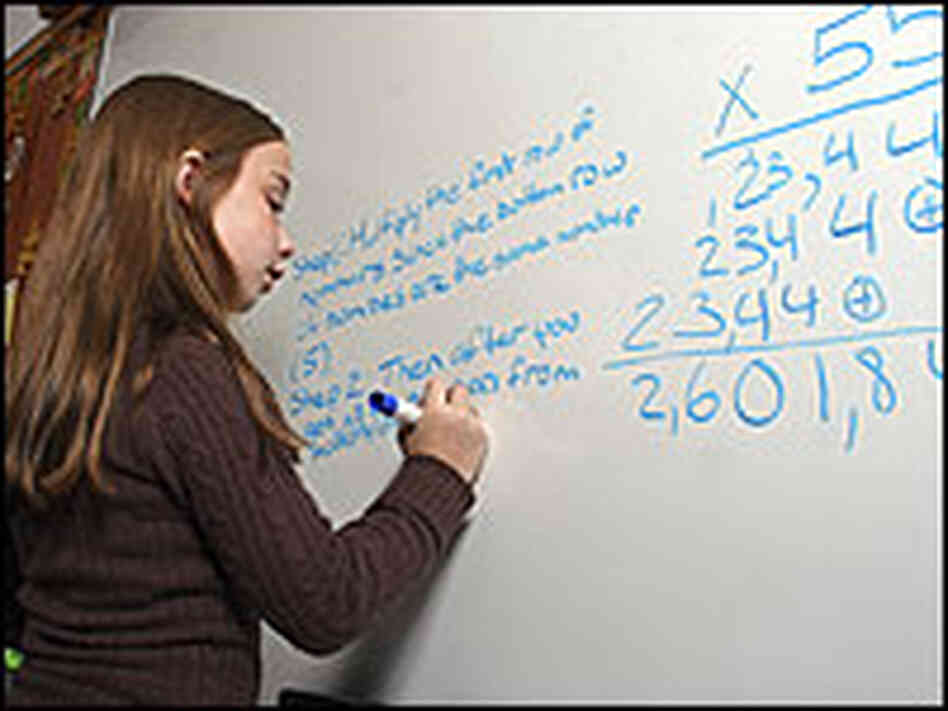 A girl works on a math problem. A girl works on a math problem.