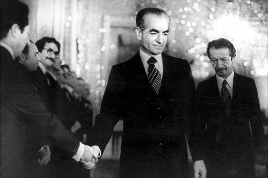 The shah shakes hands with a minister of the new civilian government, days before leaving Iran.