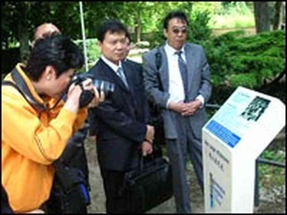 Chinese tourists visit a plaque in a park in Montargis, France.