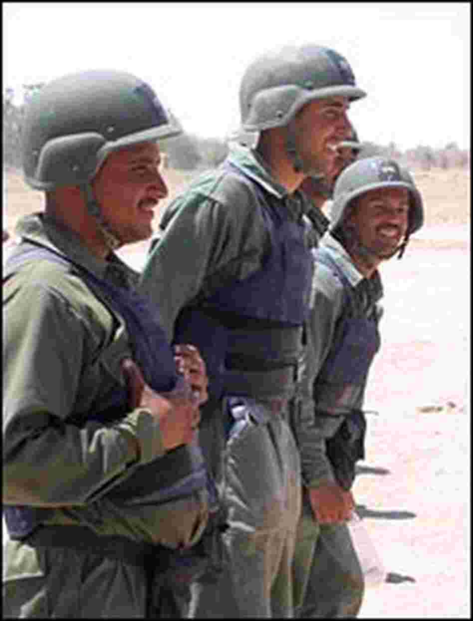 Iraqi provincial security force trainees look on during obstacle-course training drill.