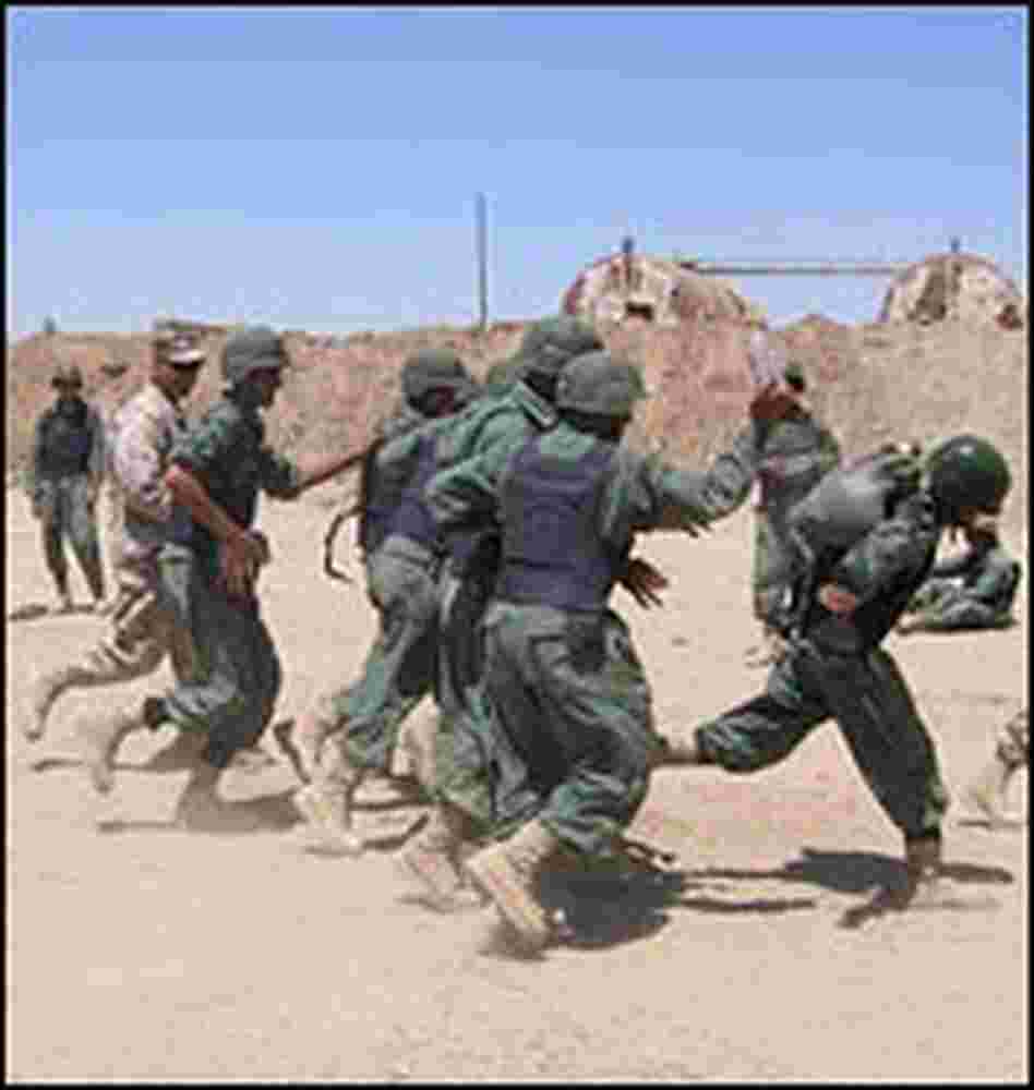 Iraqi provincial security force trainees run through an obstacle course with U.S. Marines.