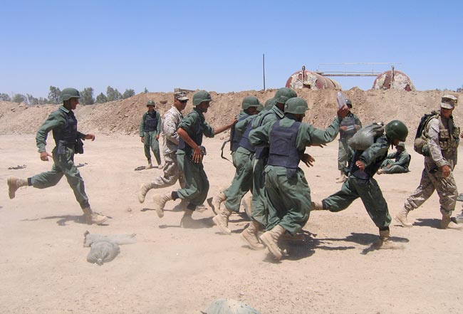Iraqi provincial security force trainees run through an obstacle course with U.S. Marines.