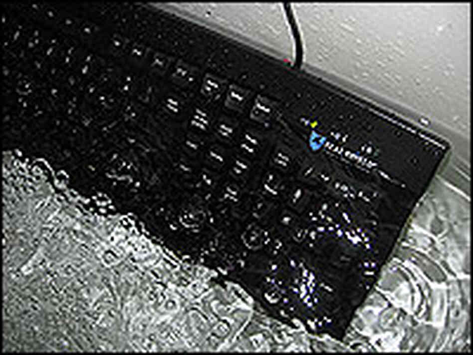 A Seal Shield computer keyboard is submerged in water in a bathtub. A Seal Shield computer keyboard is submerged in water in a bathtub.