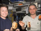 Astronaut Peggy Whitson and cosmonaut Valery Korzun eat aboard the International Space Station. Astronaut Peggy Whitson and cosmonaut Valery Korzun eat aboard the International Space Station.