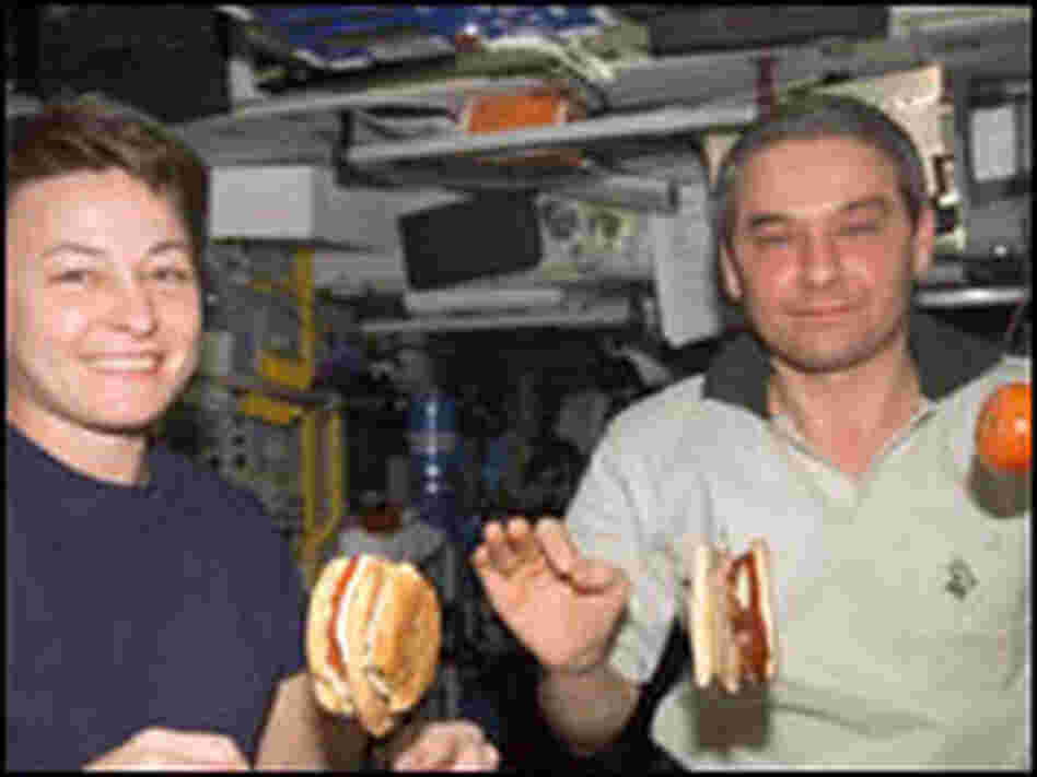 Astronaut Peggy Whitson and cosmonaut Valery Korzun eat aboard the International Space Station.
