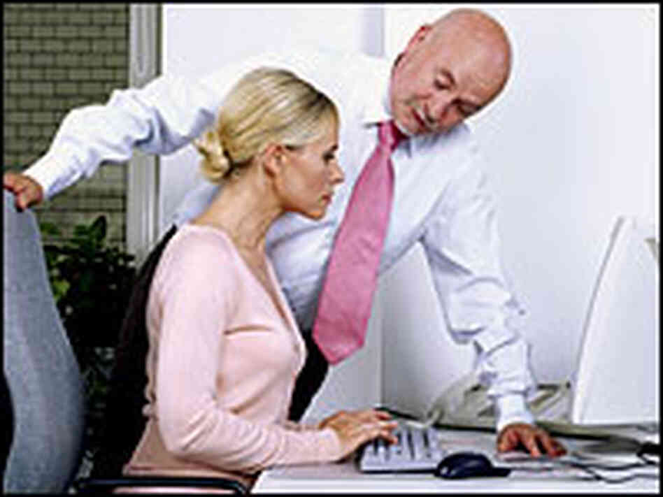 A boss hovers over his worker. A boss hovers over his worker.