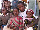 Villagers bring their families to the site where children are being tested for schistosomiasis. Villagers bring their families to the site where children are being tested for schistosomiasis.