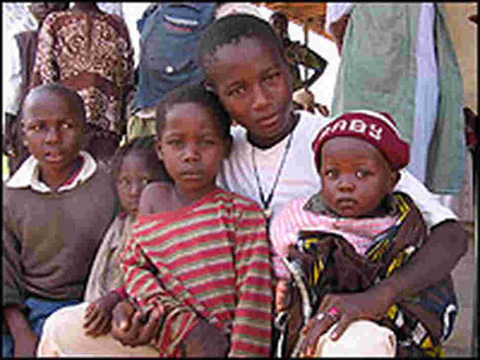 Villagers bring their families to the site where children are being tested for schistosomiasis.