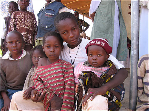 Villagers bring their families to the site where children are being tested for schistosomiasis.