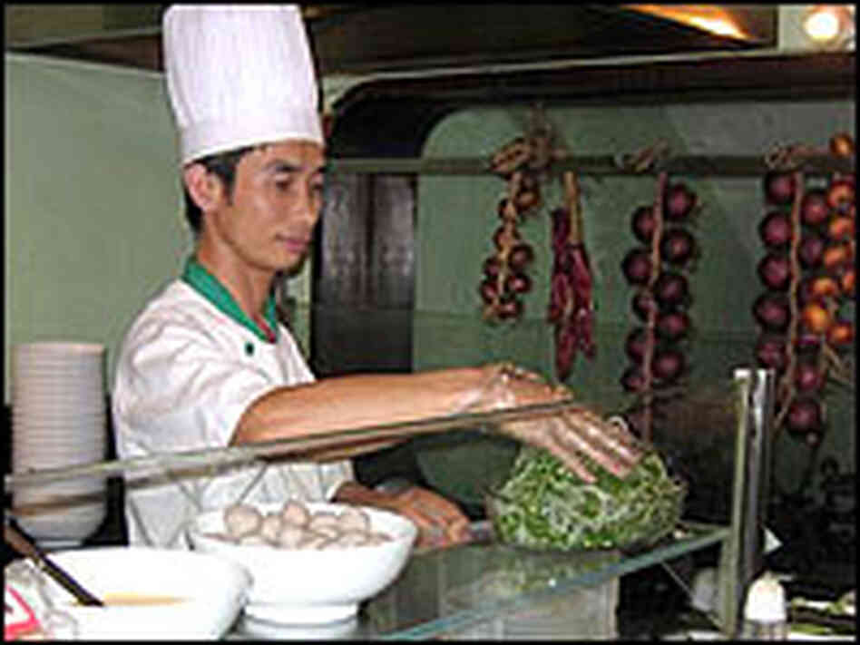 A cook prepares a dish at a Pho24 in Ho Chi Minh City.