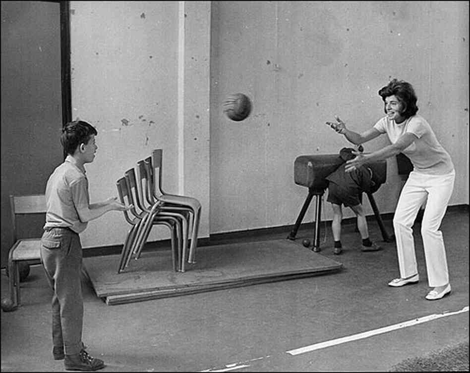 Shriver and a child play catch in a Paris gymnasium in 1969.