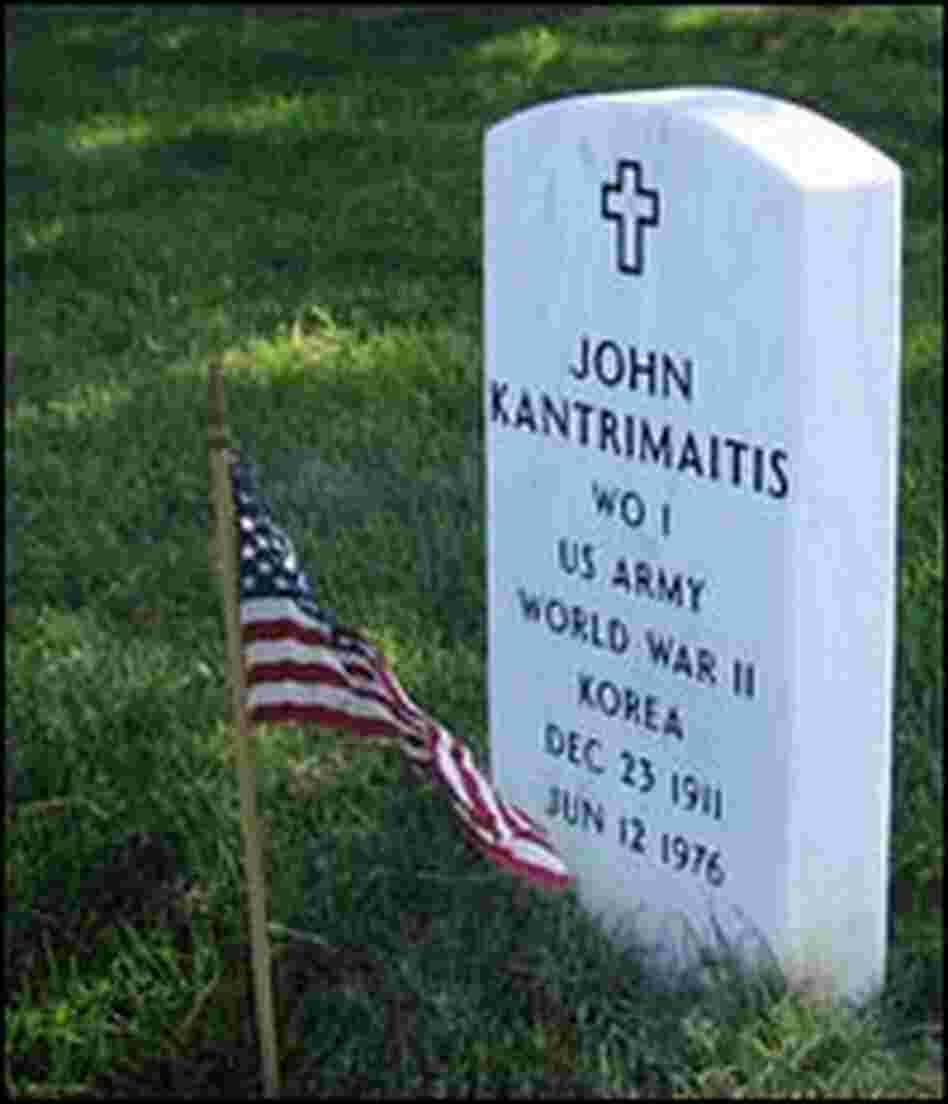 A flag in front of a headstone at the cemetery.