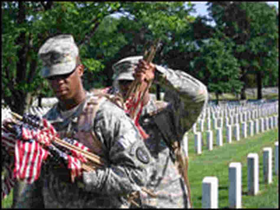 Pfc. Gabriel Gonzales makes sure that Staff Sgt. William Peyton has enough flags in his rucksack.