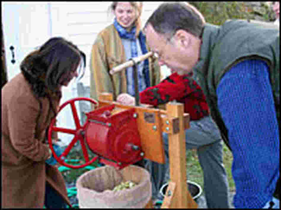 Renee Montagne and Chris Kimball press apples to make cider.
