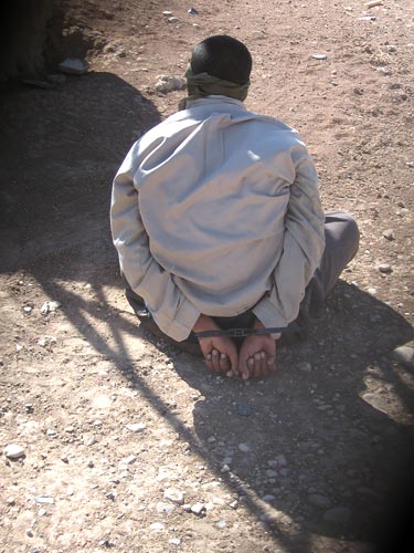 A suspected insurgent is blindfolded and handcuffed.