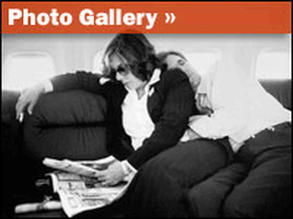 Sen. John Kerry naps aboard a plane as his wife Teresa Heinz Kerry reads a newspaper.