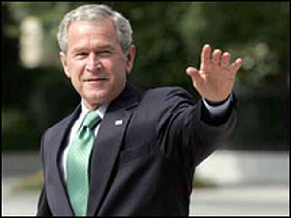President Bush waves to members of the media as he walks to the White House.