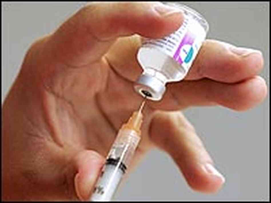 Loading a flu shot from a glass bottle into a syringe. Loading a flu shot from a glass bottle into a syringe.