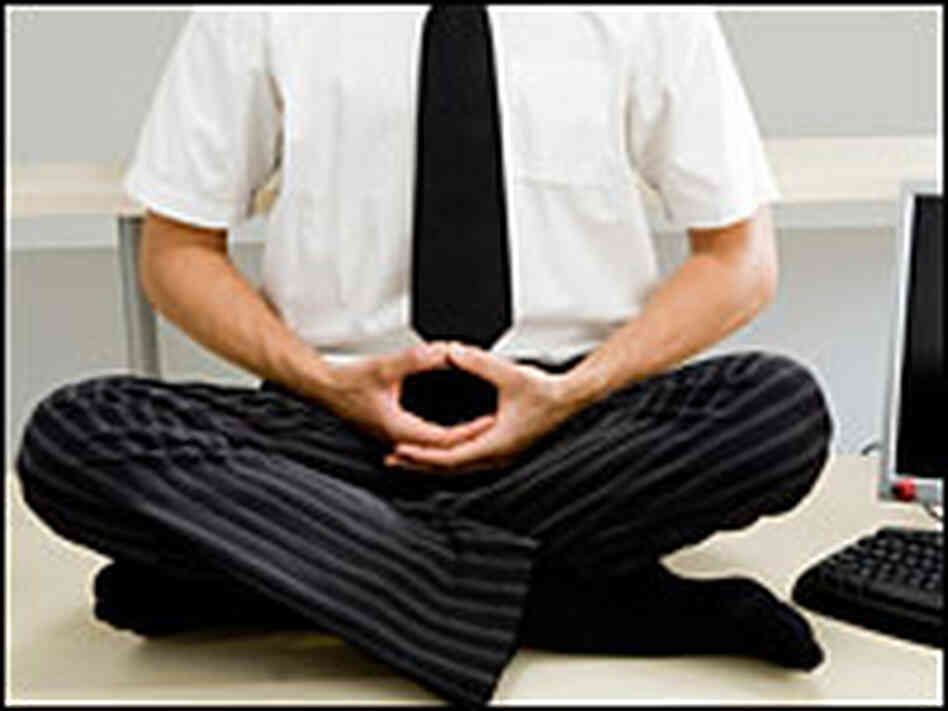 A man meditates on his desk. A man meditates on his desk.